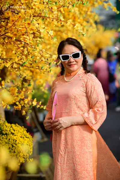 Dancesport competitor: Female dancer: peach-colored long-sleeved Ao Dai with a subtle floral pattern, p