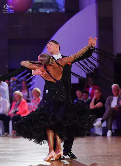 Dancesport competitor: Male dancer: black suit with a white shirt and white bowtie