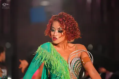 Dancesport competitor: Female dancer: bright green latin dress with long fringe and silver sequin detai