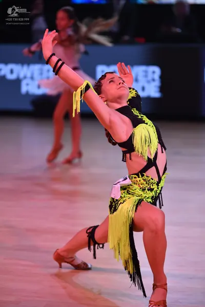 Dancesport competitor: Female dancer: black and neon yellow latin dance dress with long fringe and cuto