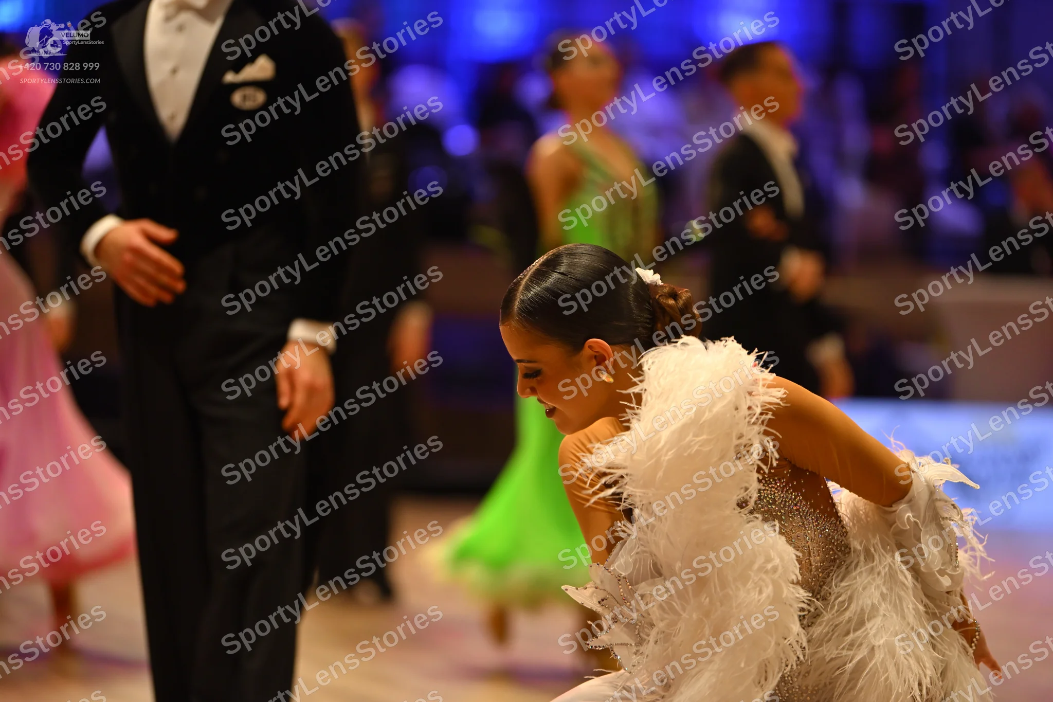 Dancesport competitor: Male dancer in foreground: black formal suit with a white shirt and white pocket