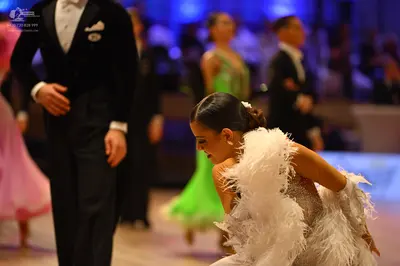 Dancesport competitor: Male dancer in foreground: black formal suit with a white shirt and white pocket