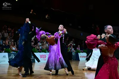 Dancesport competitor: Female dancer (left): navy blue ballroom gown