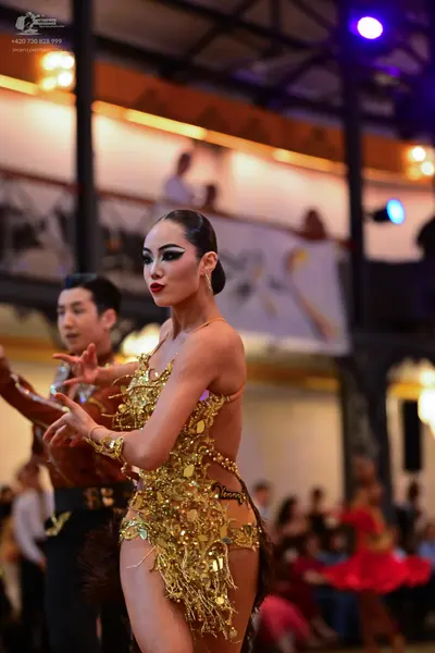 Dancesport competitor: Female dancer: gold latin dress with heavy sequin and metallic fringe embellishm