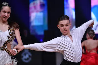Dancesport competitor: Female dancer (left): white Latin dance costume with leopard print accents, cuto