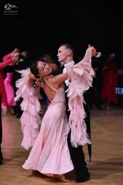 Dancesport competitor: Main female dancer: light pink ballroom gown with large, voluminous, feathery sl