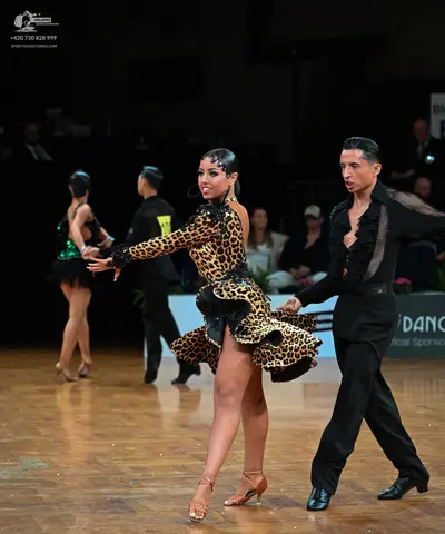 Dancesport competitor: Female dancer: leopard print latin dress with long sleeves, a ruffled hem with b