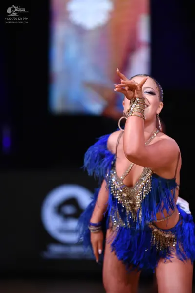 Dancesport competitor: Female dancer: blue Latin dance costume with blue fringe and gold/silver sequin 