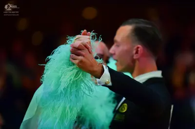 Dancesport competitor: Male dancer: black suit with a white shirt and gold cufflink