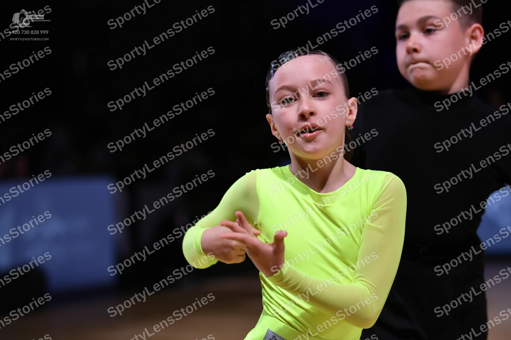 Dancesport competitor: Female dancer: lime green long-sleeved top made of stretchy fabric