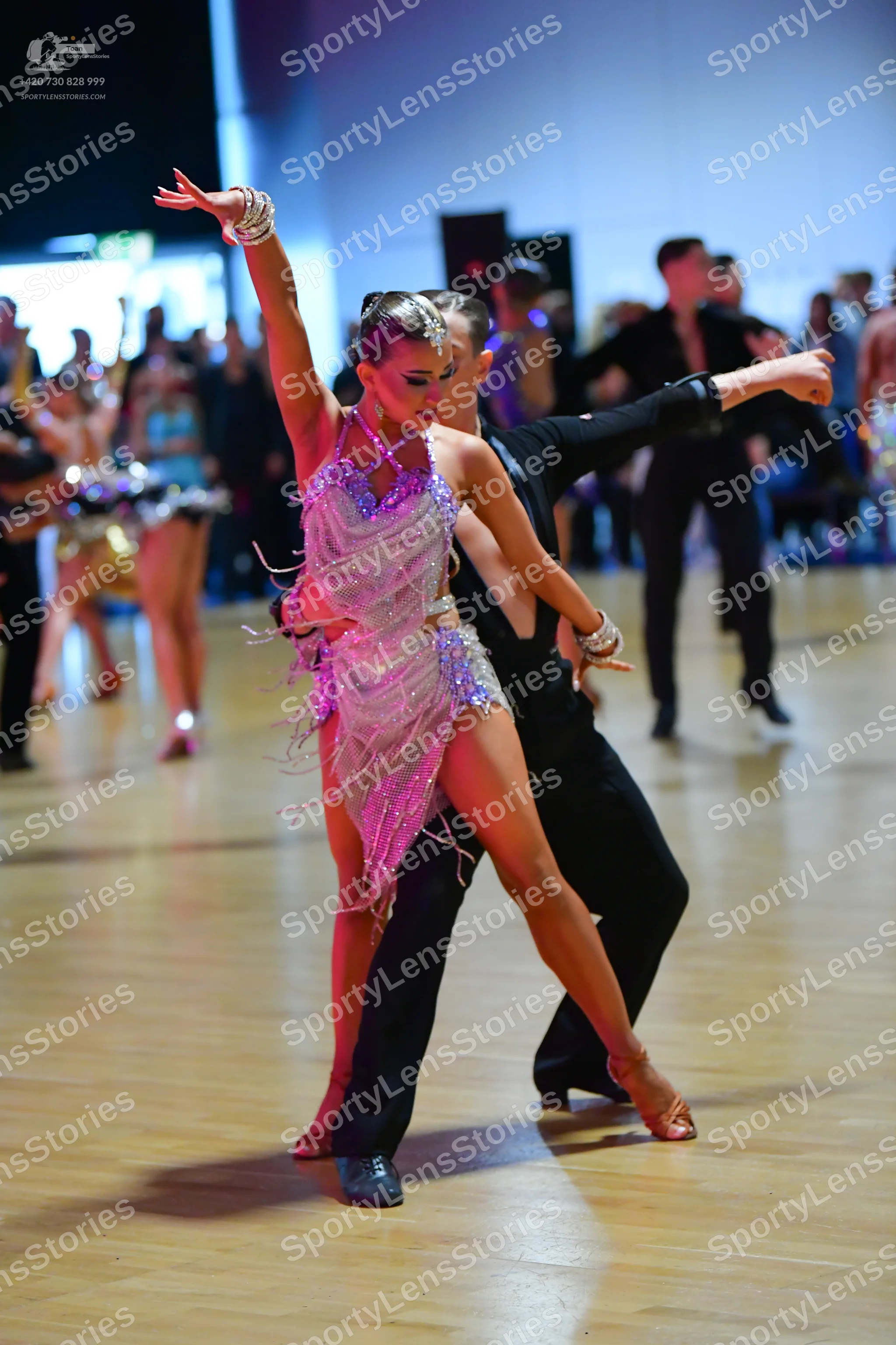 Dancesport competitor: Female dancer: light lavender/silver Latin dress with sequins and long fringe, a
