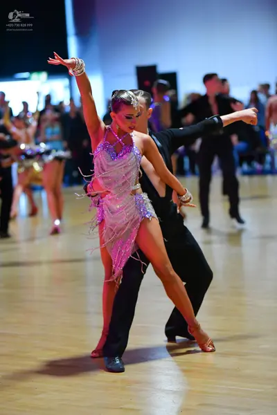 Dancesport competitor: Female dancer: light lavender/silver Latin dress with sequins and long fringe, a