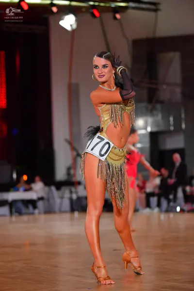 Dancesport competitor #170: Female dancer in foreground: gold Latin dress with sequin details and long fring