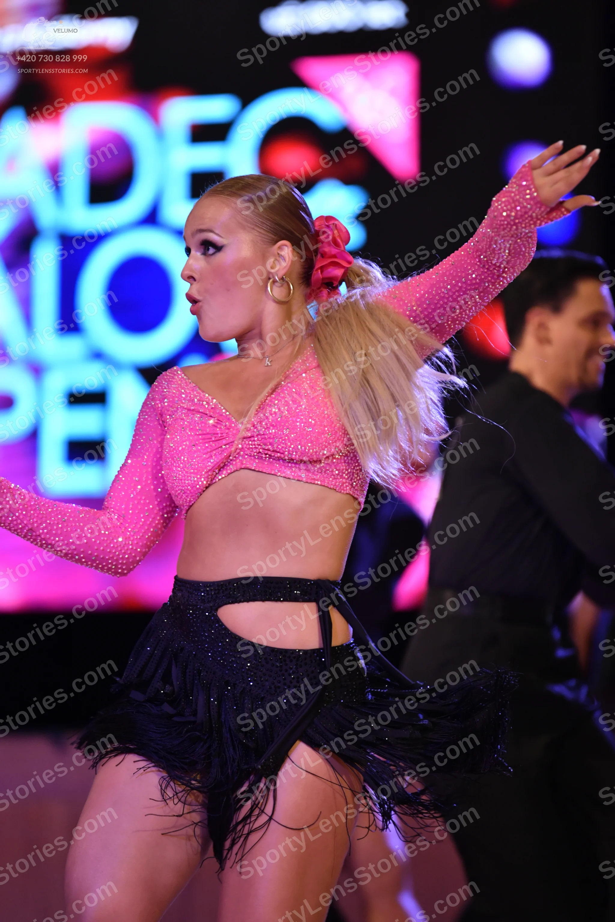 Dancesport competitor: Female dancer: pink sequined long-sleeved crop top and black sequined skirt with