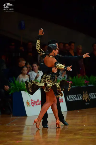 Dancesport competitor: Female dancer: leopard print latin dress with long sleeves and an open back