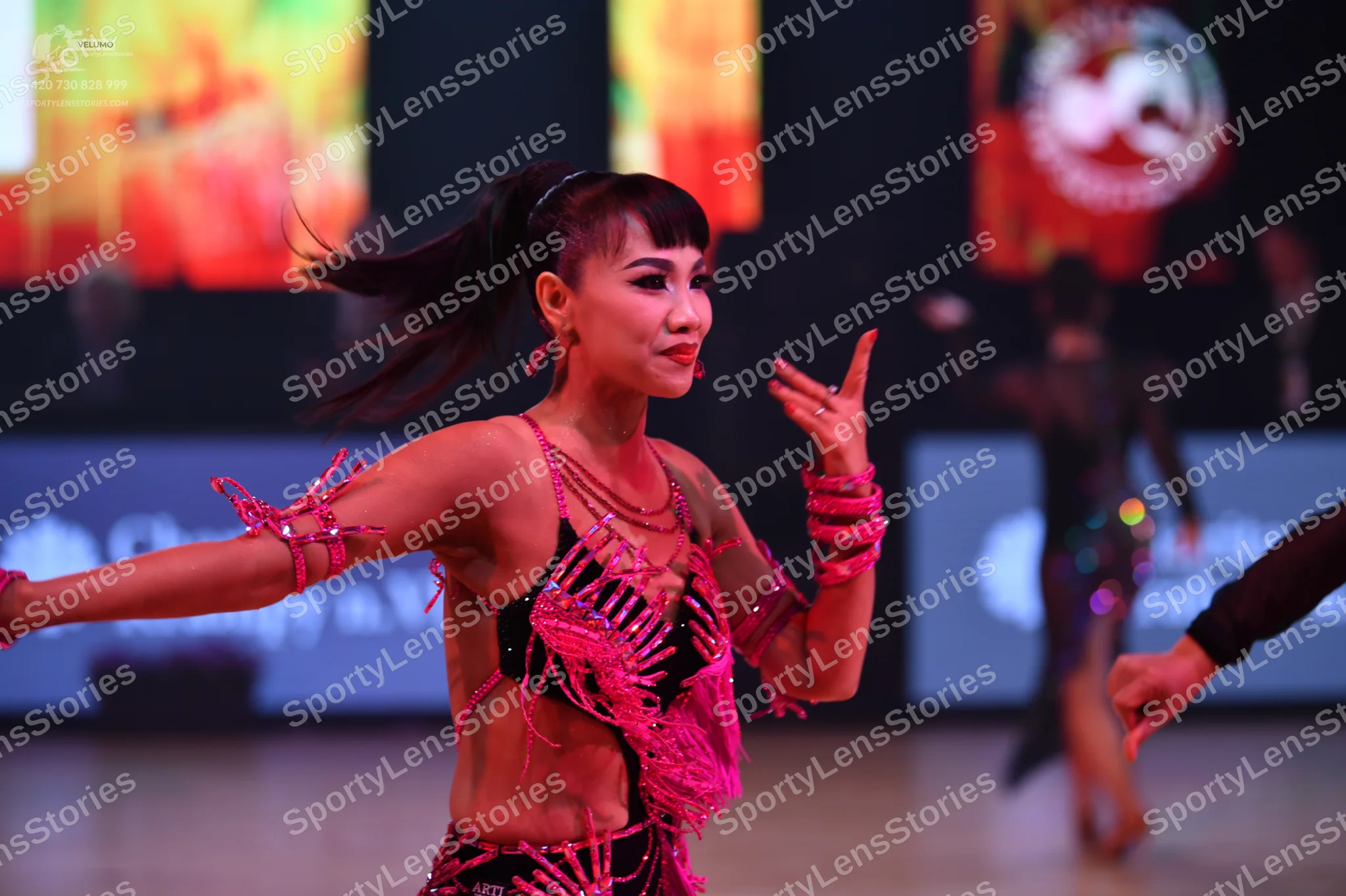 Dancesport competitor: Main female dancer: pink Latin costume with heavy sequin and crystal embellishme
