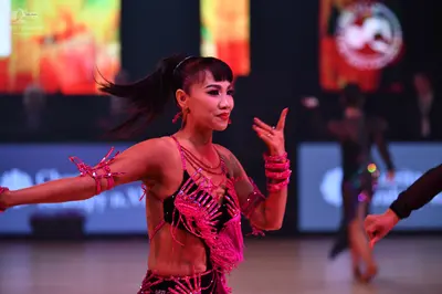 Dancesport competitor: Main female dancer: pink Latin costume with heavy sequin and crystal embellishme