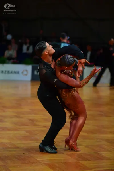 Dancesport competitor: Male dancer: black long-sleeved top and black trousers