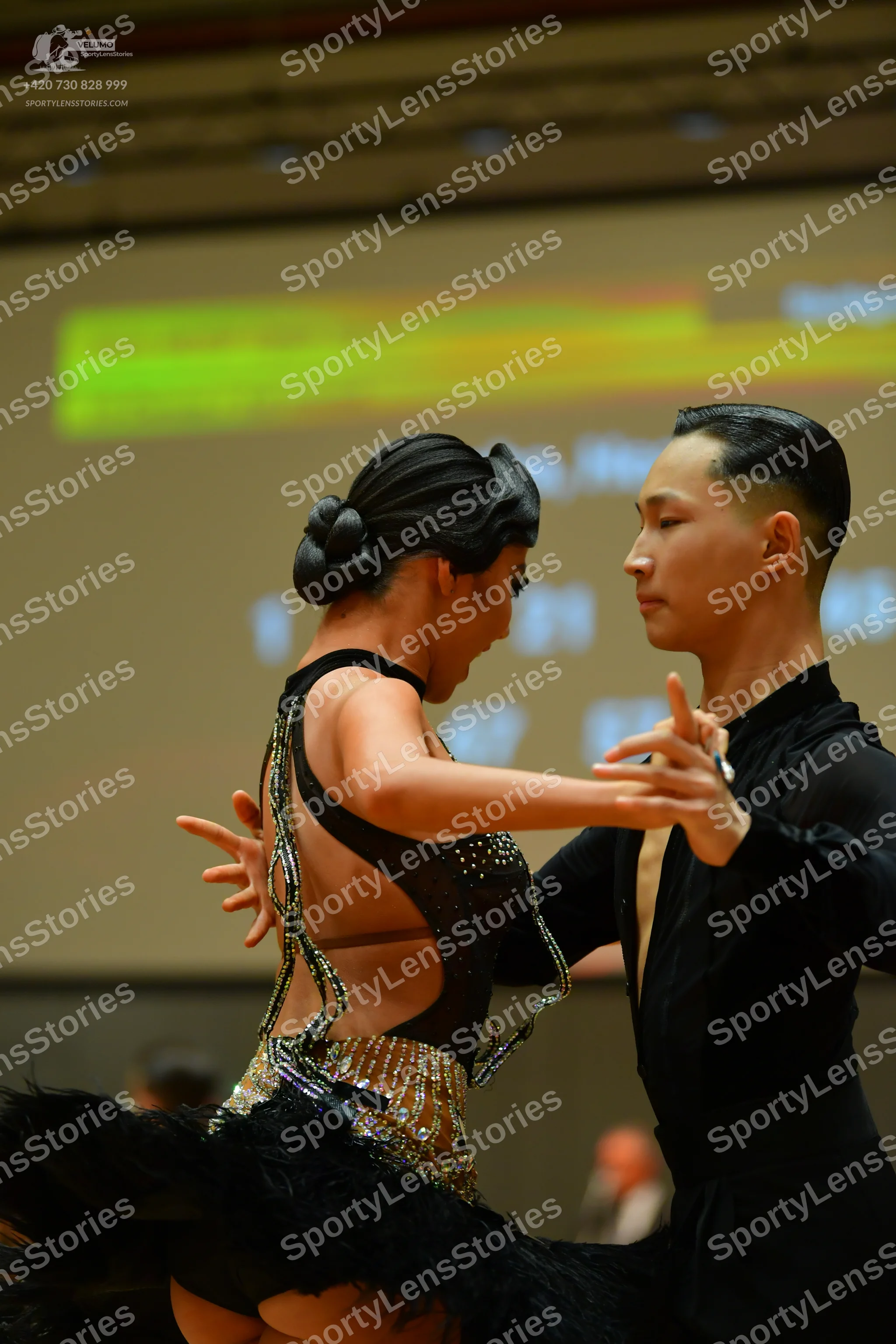 Dancesport competitor: Female dancer: black latin dress with sequin embellishments and large black feat