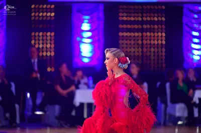 Dancesport competitor: Female dancer: red latin dress with long sleeves and heavy fringe