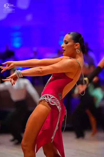 Dancesport competitor: Female dancer: magenta Latin dress with silver sequin/crystal patterns and lace 