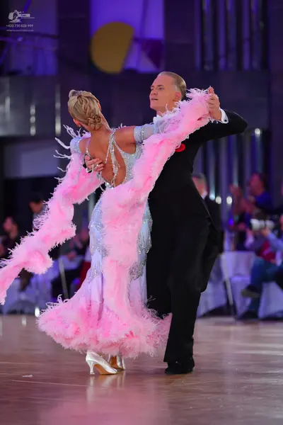 Dancesport competitor: Female dancer: light blue sequined ballgown with a voluminous pink feather boa