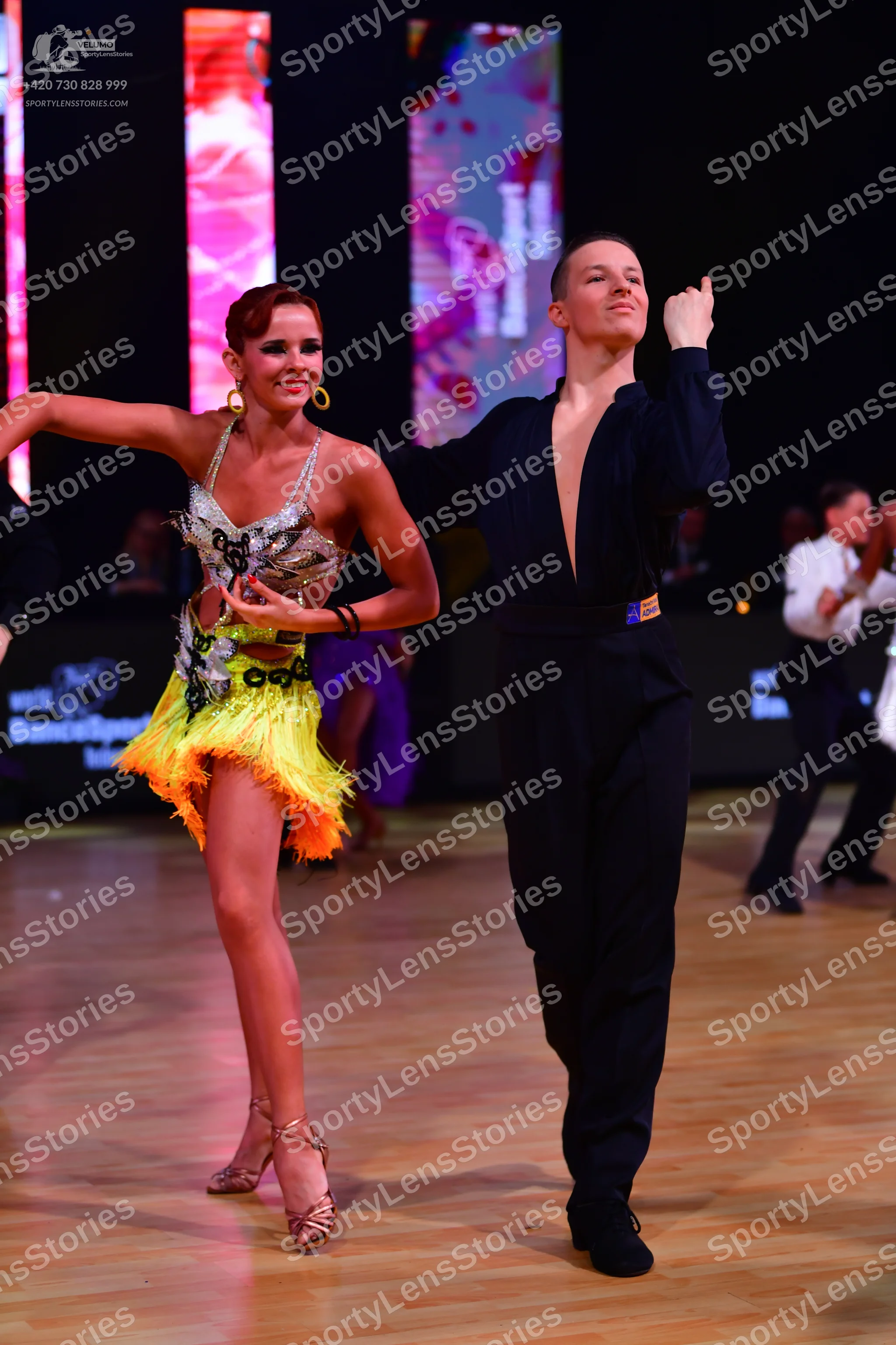 Dancesport competitor: Female dancer: silver sequined Latin dress with bright yellow fringe and large g
