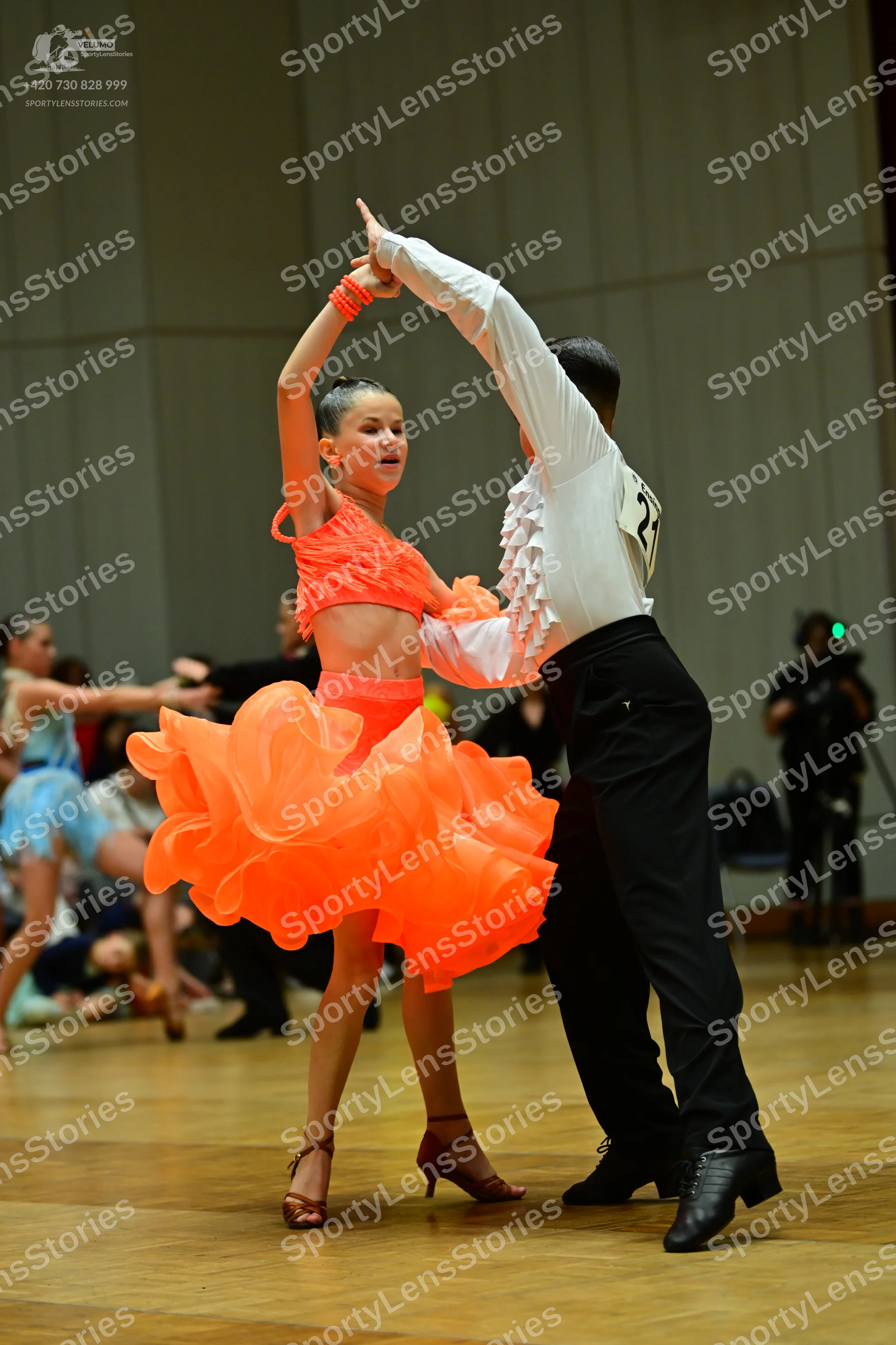 Dancesport competitor: Male dancer: white long-sleeved shirt with ruffles on the sleeves and front, bla