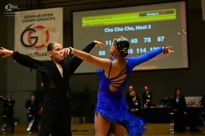 Dancesport competitor: Dancer on left: black long-sleeved dance outfit
