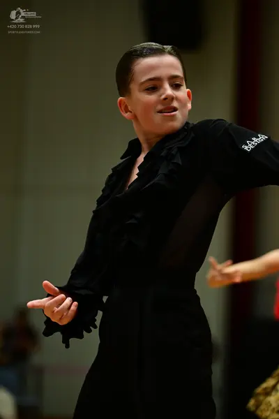 Dancesport competitor: Main dancer: black long-sleeved dance costume with ruffles along the front and c