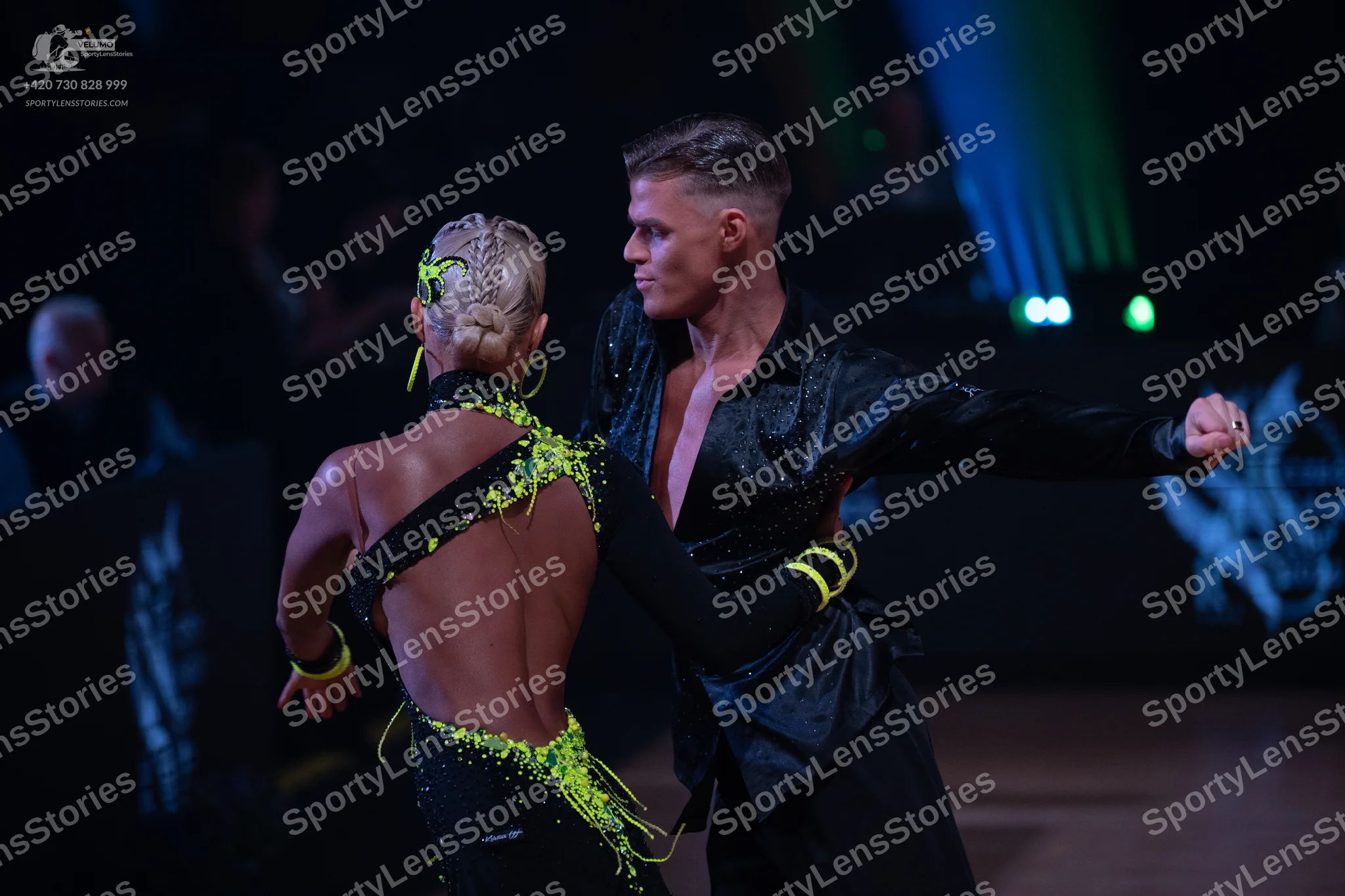 Dancesport competitor: Female dancer: black latin dance costume with lime green accents and an open bac