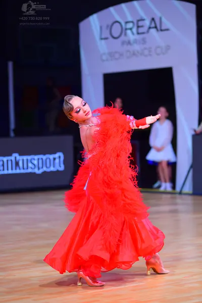 Dancesport competitor: Female dancer: red ballroom dress with voluminous ruffled layers
