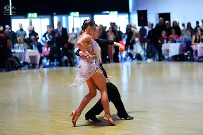 Dancesport competitor: Female dancer: silver/white latin dress with long fringe and nude-colored strapp