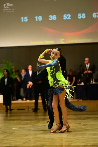 Dancesport competitor: Female dancer: lime green and dark grey latin dress with long fringe and matchin