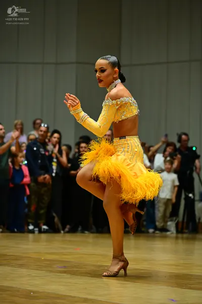 Dancesport competitor #1638: Female dancer: bright yellow Latin dance costume featuring a sequined crop top w