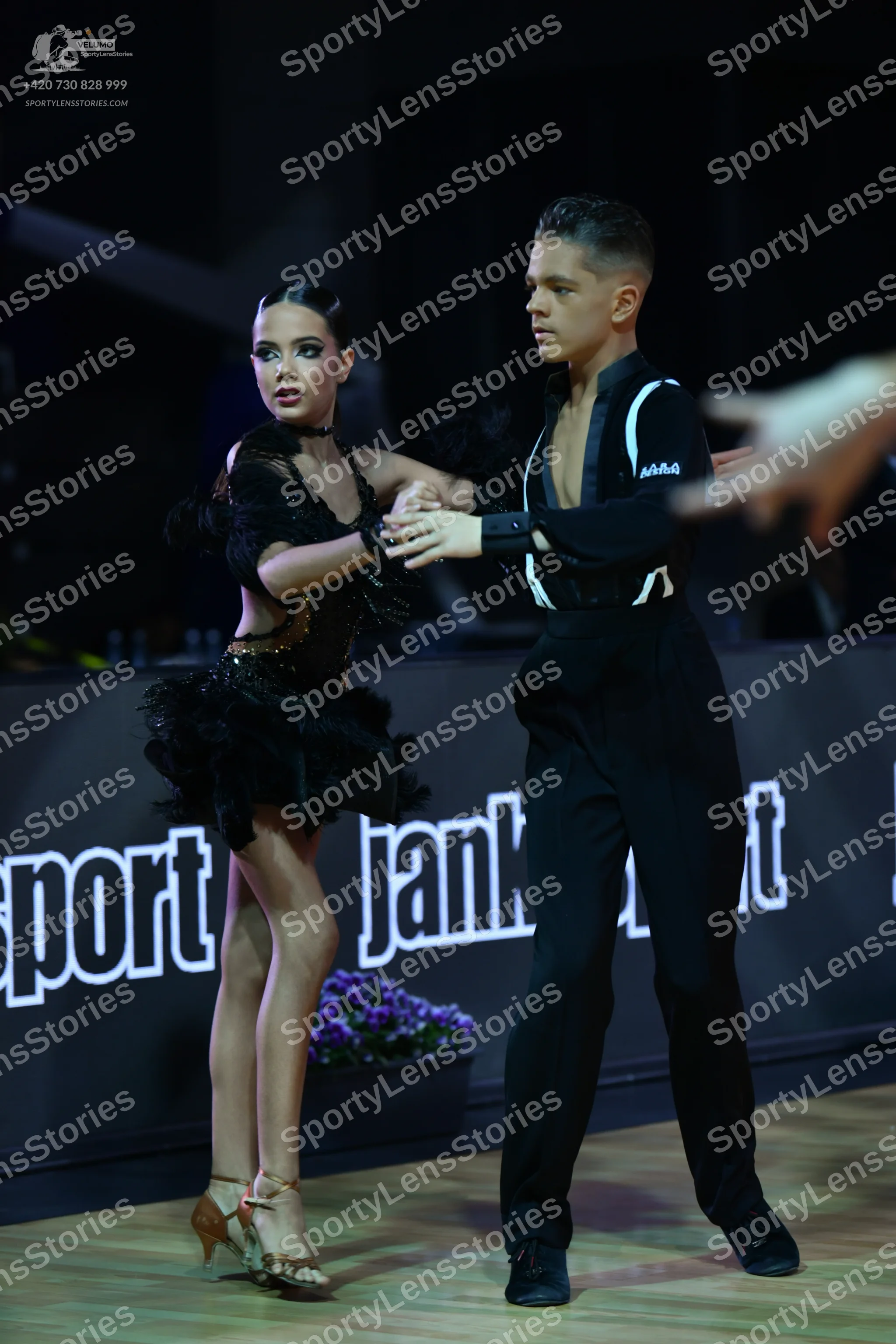 Dancesport competitor: Female dancer: black latin dress with ruffled skirt and sequin details, black ch