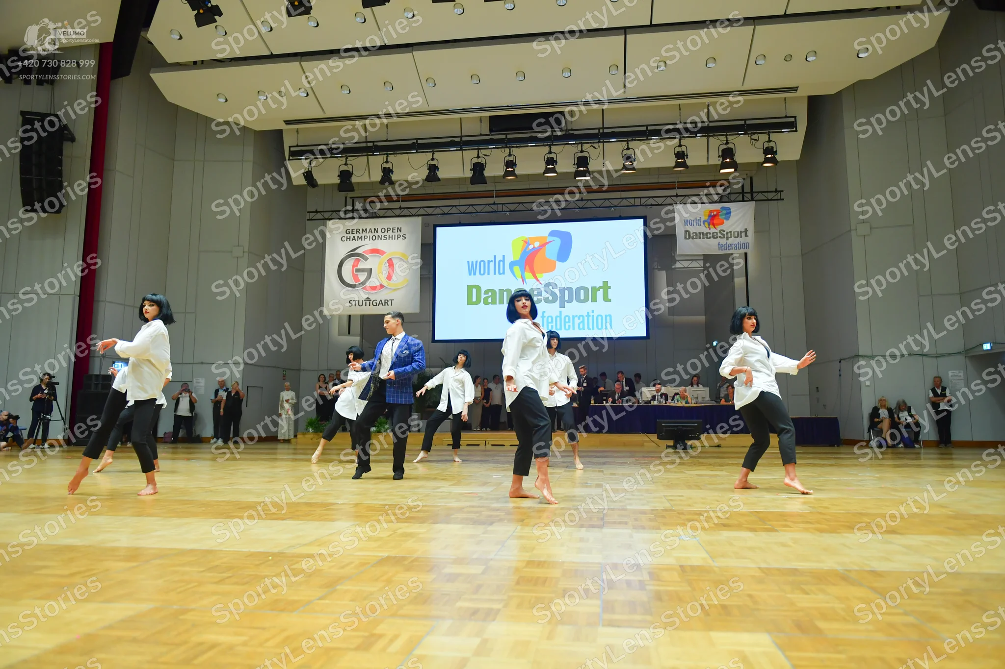 Dancesport competitor: All visible female dancers are wearing matching costumes consisting of a white l
