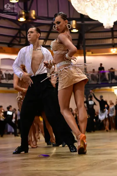 Dancesport competitor: Male dancer: white long-sleeved shirt open at the chest and black trousers