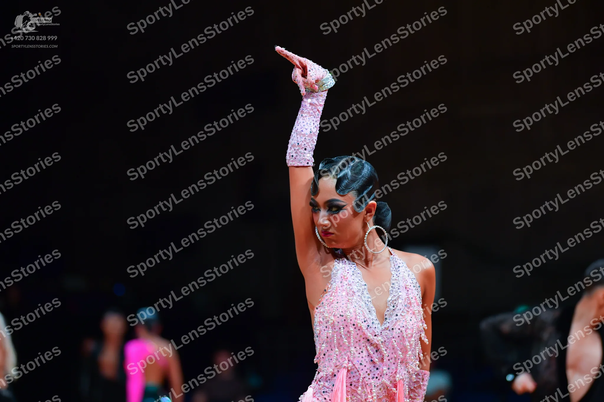 Dancesport competitor: Female dancer (foreground): light pink Latin dress with heavy sequin/crystal emb