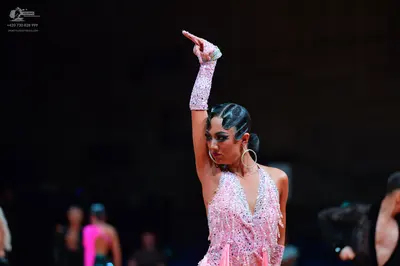 Dancesport competitor: Female dancer (foreground): light pink Latin dress with heavy sequin/crystal emb