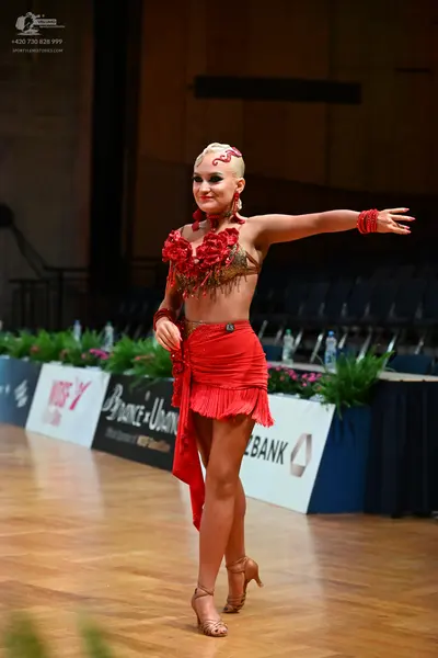 Dancesport competitor: Female dancer: red latin dress with floral embellishments and fringe