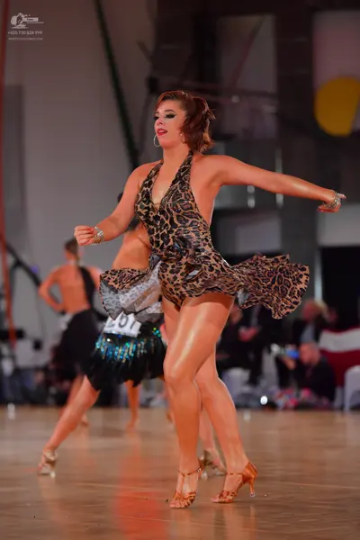 Dancesport competitor #65: Female dancer in foreground: leopard print latin dress with a short, flared skir
