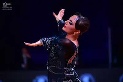 Dancesport competitor: Female dancer: black latin dance dress made of sheer black fabric with heavy sil