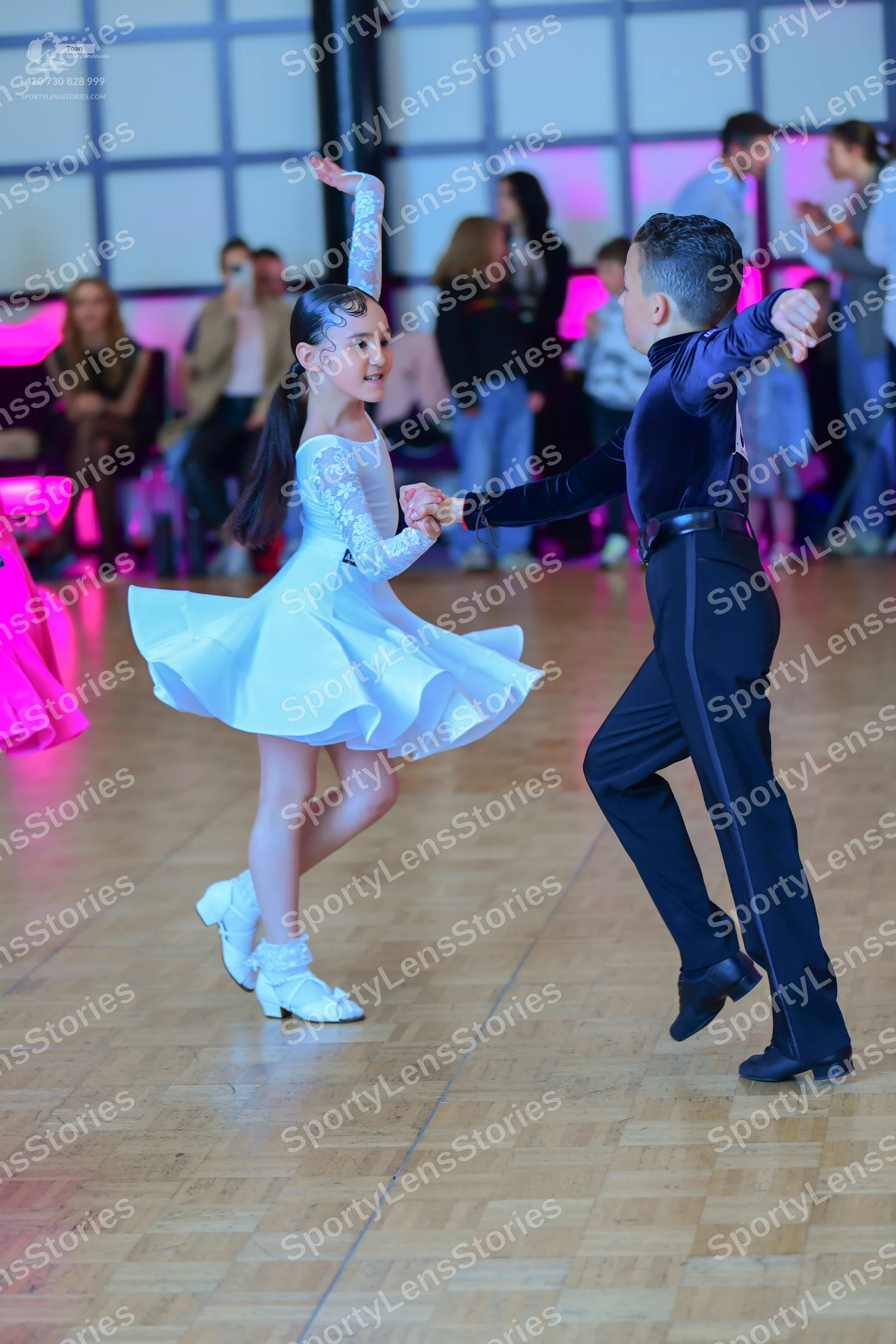 Dancesport competitor: Female dancer: white Latin dance dress with lace long sleeves and a flared skirt