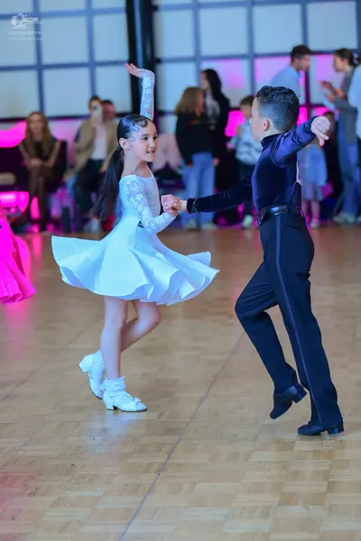 Dancesport competitor: Female dancer: white Latin dance dress with lace long sleeves and a flared skirt