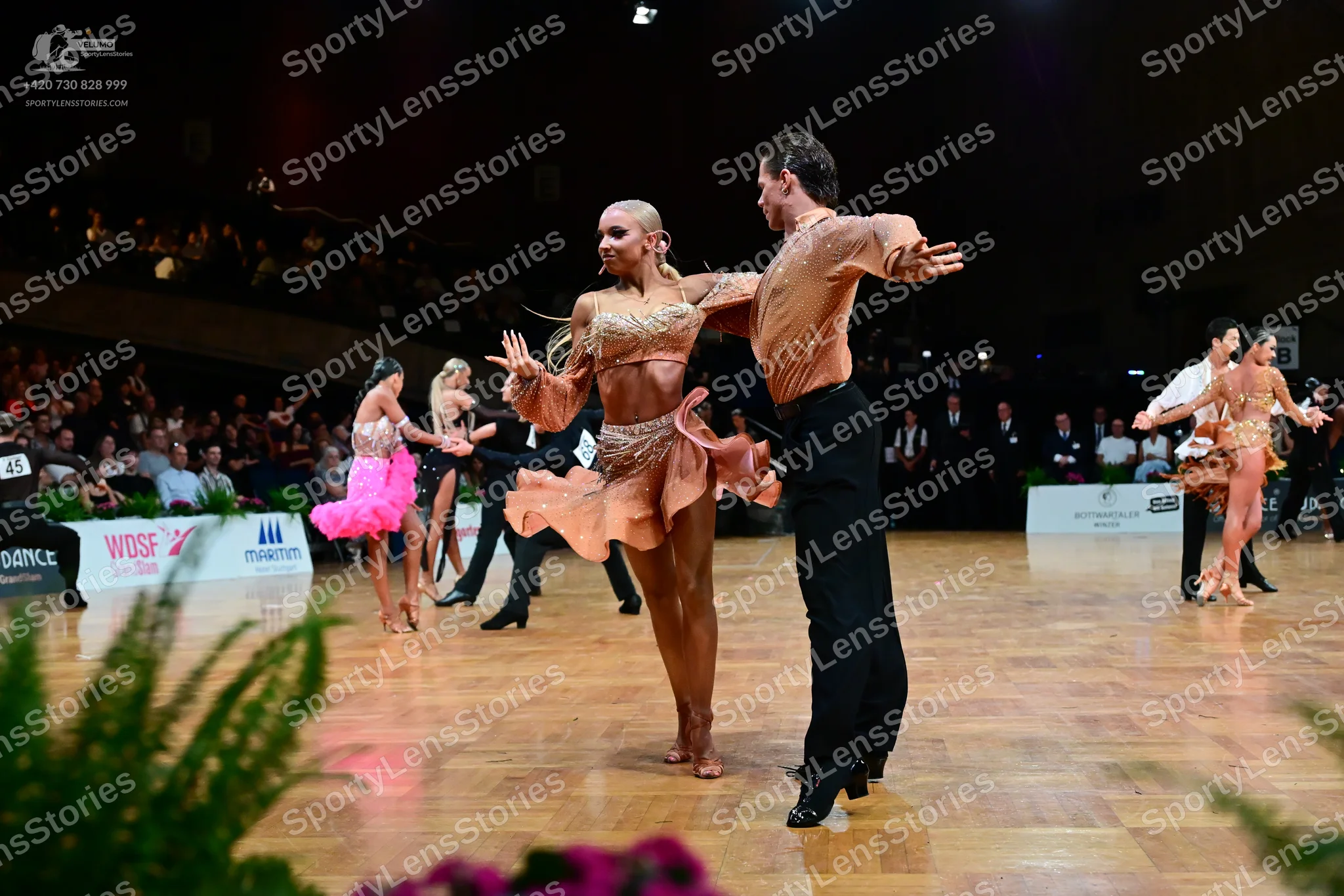 Dancesport competitor #45: Main female dancer: tan Latin dress with sequins, lace, and a ruffled skirt