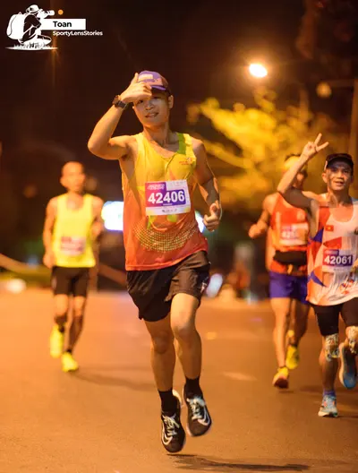 Marathon runner #42406, #42061: Runner 1: yellow/orange tank top, black shorts, black socks, black and white sho