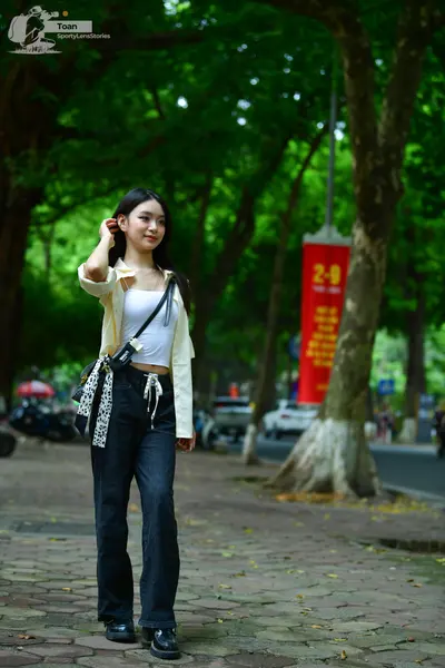 Dancesport competitor: Female dancer: white tank top, light yellow open shirt, dark blue wide-leg jeans