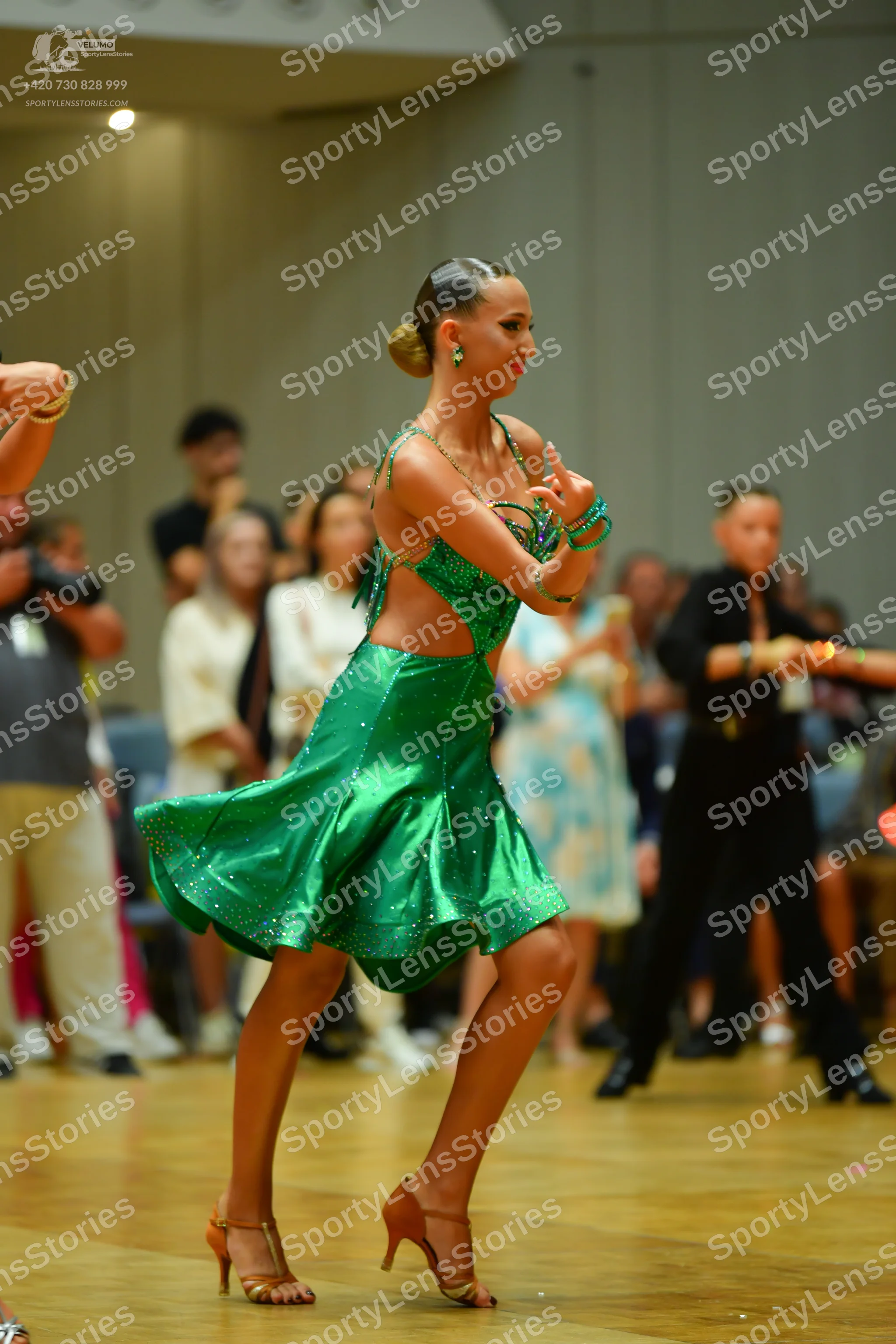 Dancesport competitor: Female dancer: emerald green satin latin dress with thin straps and a flared ski