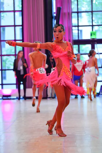 Dancesport competitor #160: Female dancer: pink latin dress with fringe and gold embellishments, gold bracel